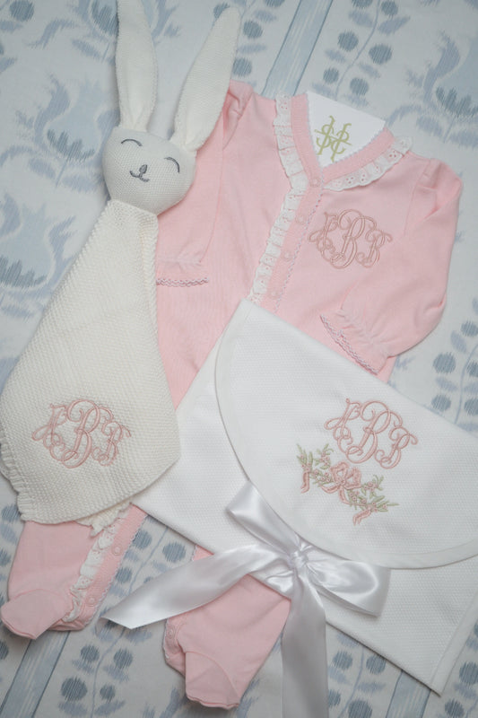 Personalized baby gift bundle with coordinating pieces and embroidered monogram; styled view