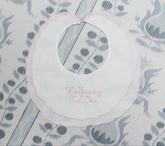 Personalized scalloped halfway to one heirloom bib with custom embroidery from Saul Stitch House; styled view