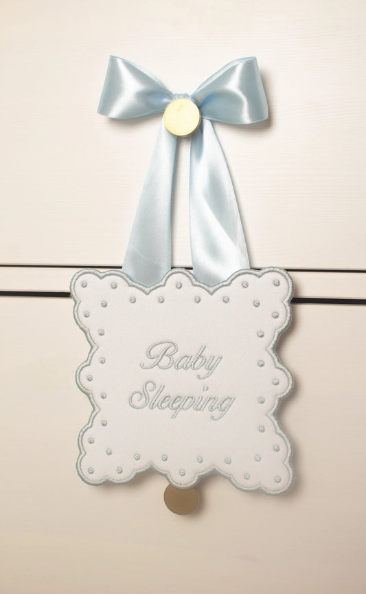 Personalized sleeping baby door sign with custom embroidery from Saul Stitch House; styled view