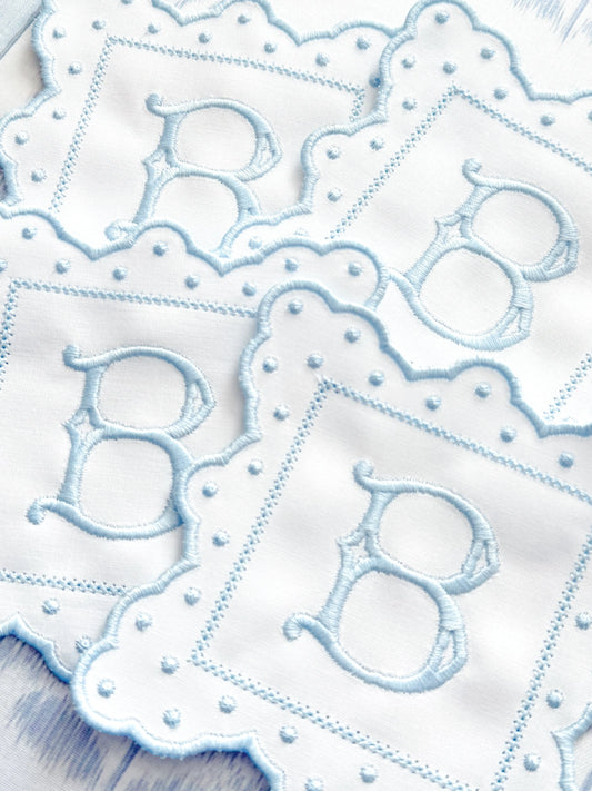 Set of fancy scalloped monogram coasters with personalized embroidery for entertaining; styled view
