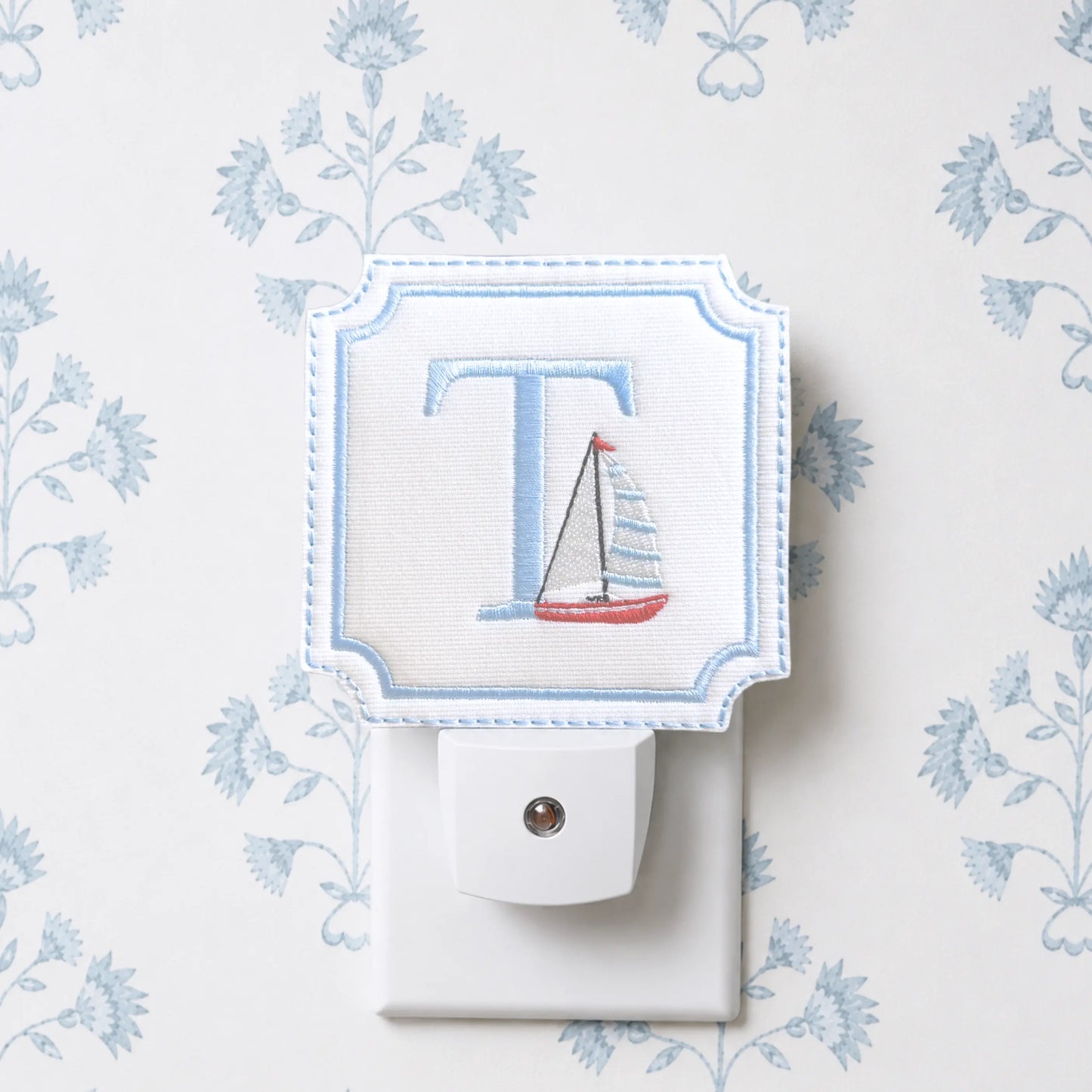 Embroidered sailboat night light with decorative fabric cover for a nursery, hallway, or powder room