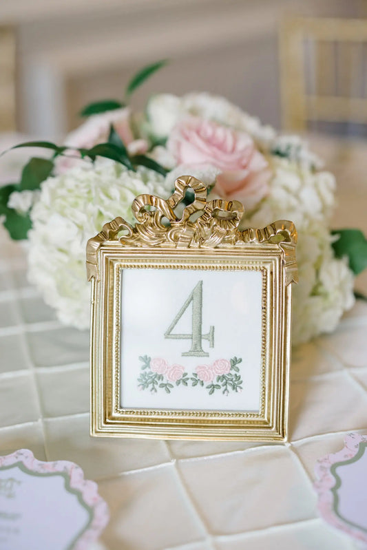 Custom wedding table number with embroidery designed to coordinate with reception décor; styled view