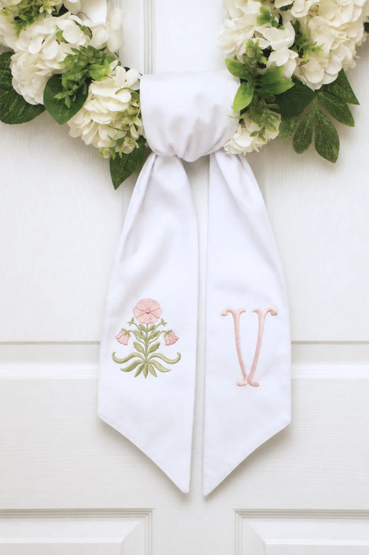 Personalized elizabeth block floral wreath sash with embroidered motif for a decorative front door wreath; styled view
