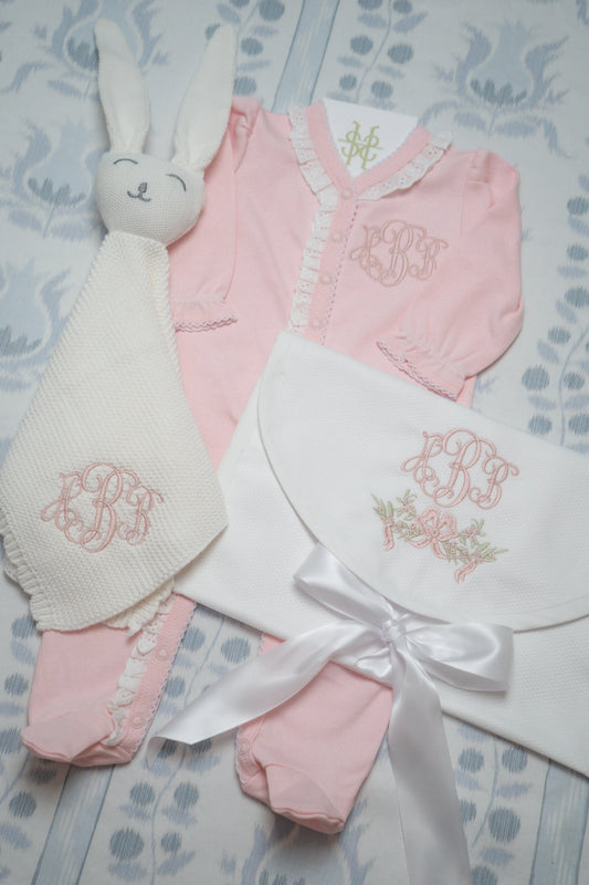 Personalized bunny lovey, keepsake bag, and lace trim footie bundle with custom embroidery for a newborn; styled view