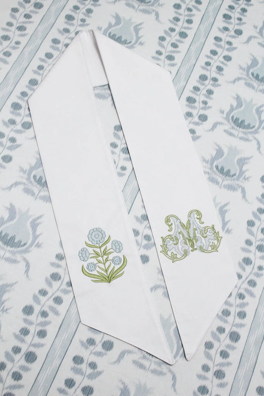 Personalized block print floral wreath sash with embroidered motif for a decorative front door wreath; styled view