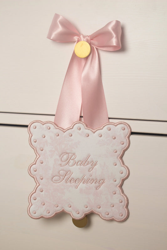 Personalized toile sleeping baby door sign with custom embroidery from Saul Stitch House; styled view