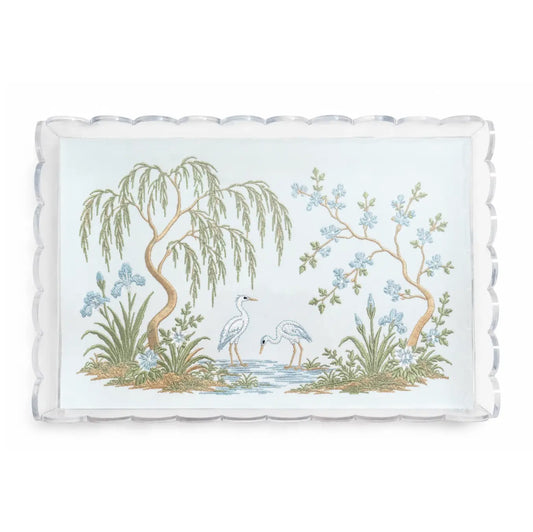 Clear scalloped acrylic tray with embroidered chinoiserie garden scene, two white herons, trees, and blue flowers