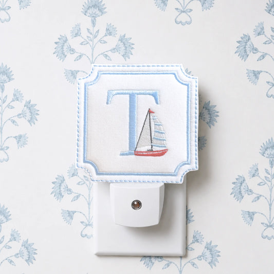 Embroidered sailboat night light with decorative fabric cover for a nursery, hallway, or powder room
